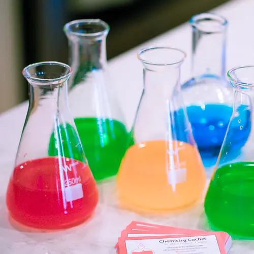 Colorful beakers on table.
