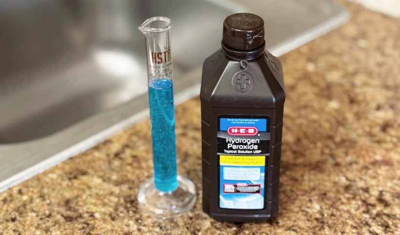 dish soap and peroxide by a kitchen drain